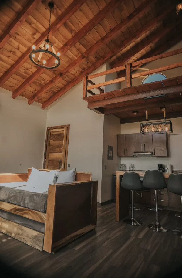 Interior de cabaña del Hotel 7 Valles en Valle de Guadalupe con techo de madera rústico.