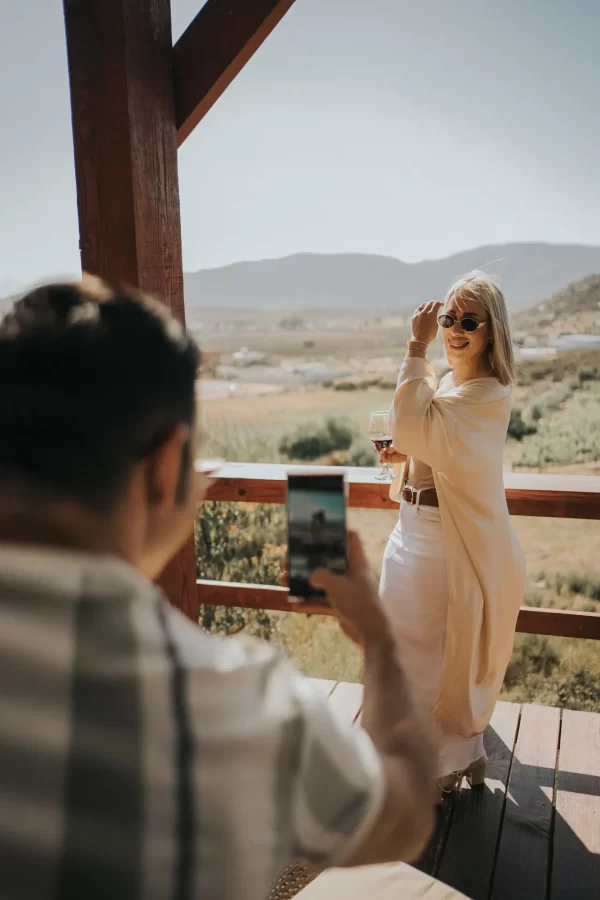 Pareja disfrutando de la vista a los viñedos desde el balcón del Hotel 7 Valles en Valle de Guadalupe.
